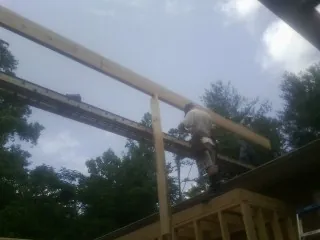 Carpenter setting a ridge beam over a new addition frame — Ice Dam Removal by Roofing Brothers in Cumberland Foreside