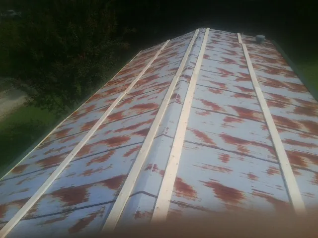 Rusted metal roof panels with new wood purlins before replacement — Storm Damage Roof Repair in Cumberland Foreside by Roofing Brothers