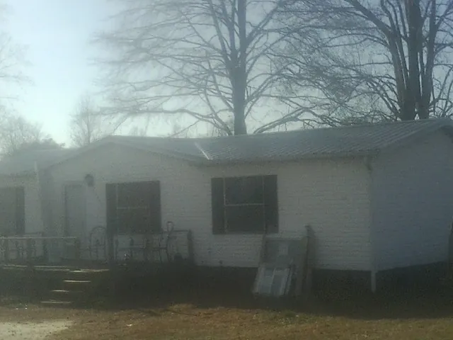New metal roof on a white painted brick home on a foggy morning in Cumberland Foreside