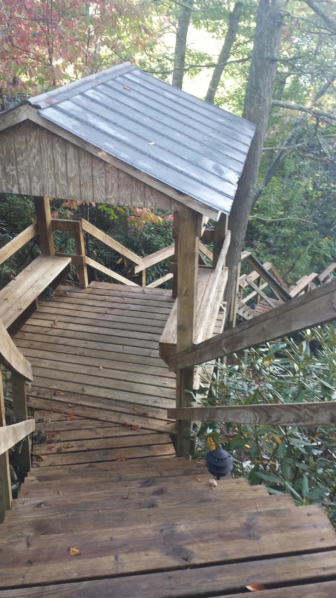 Metal roofed shelter over wooden steps on a wooded walkway — Skylight Repair & Installation work by our crew in Cumberland Foreside