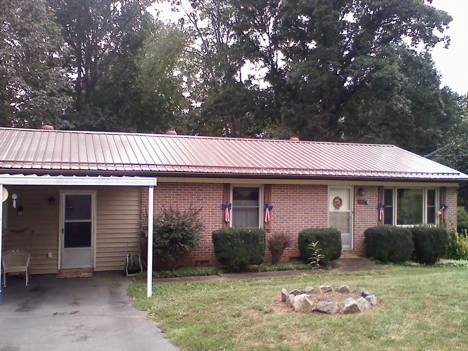 Bronze metal roof and carport on a brick ranch home — Roof Repair work by our crew in Cumberland Foreside
